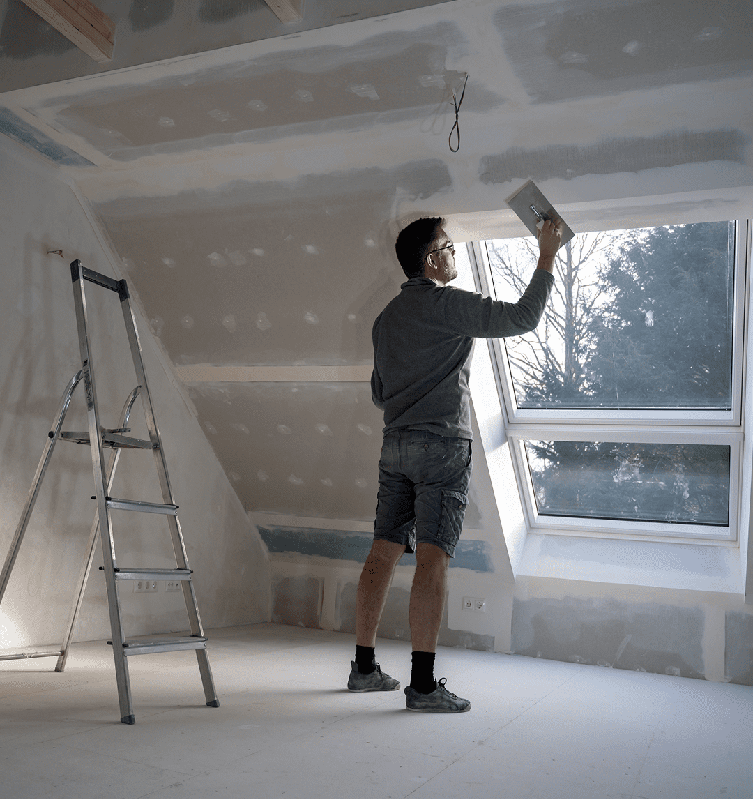 Person renovating room near skylight window.