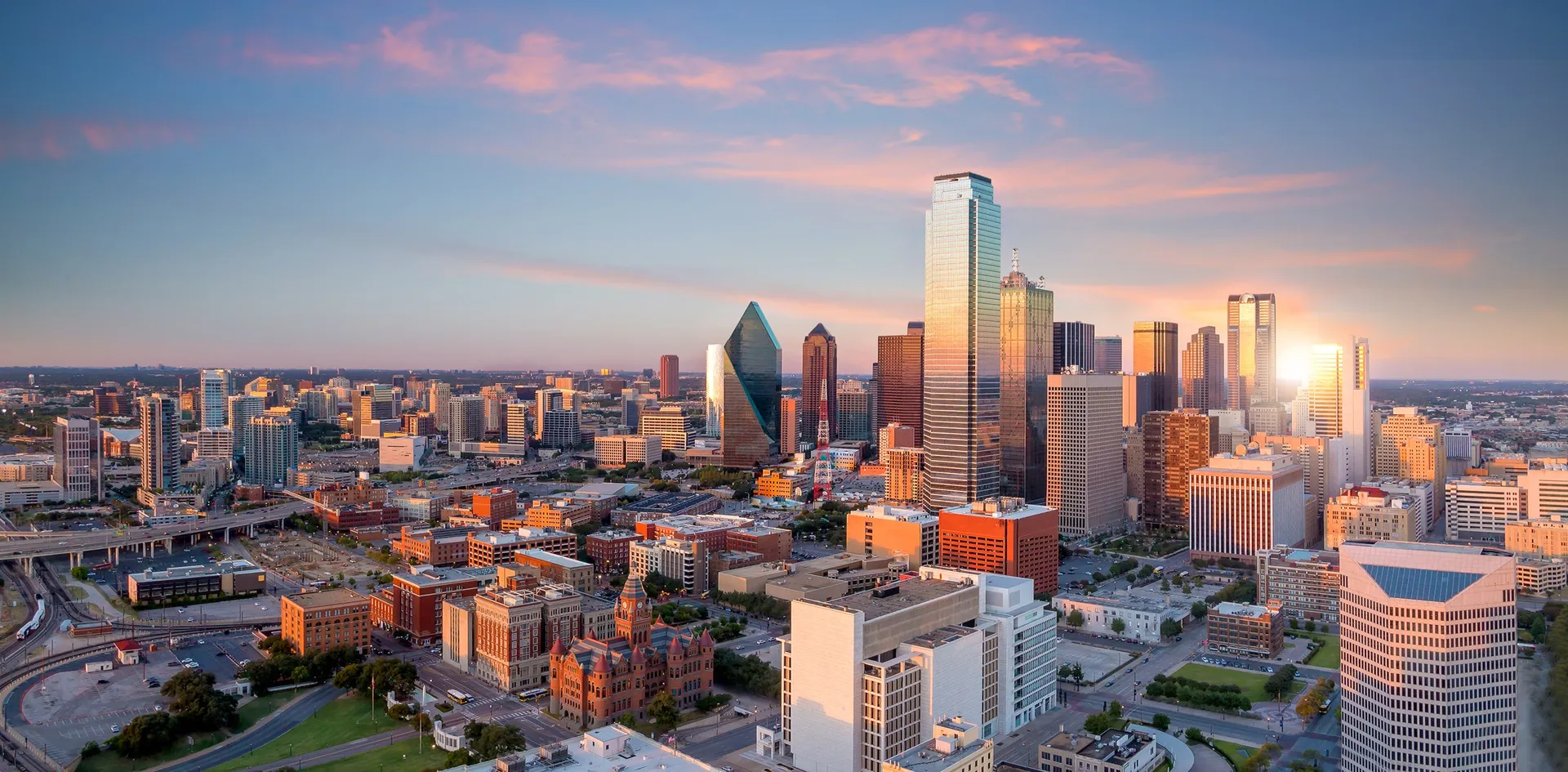 Sunset over a modern city skyline with reflective skyscrapers.